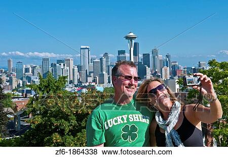 Seattle, Washington skyline from Queen Anne's Hill with couple taking photos and Mt Rainier visable in background View Large Photo Image Stock Photo - Seattle, Washington skyline from Queen Anne's Hill with couple taking photos and Mt Rainier visable in background. Fotosearch