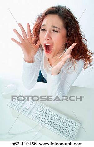 Stock Photograph - Secretary stressed in the office, screaming with her hands over her mouth. Fotosearch