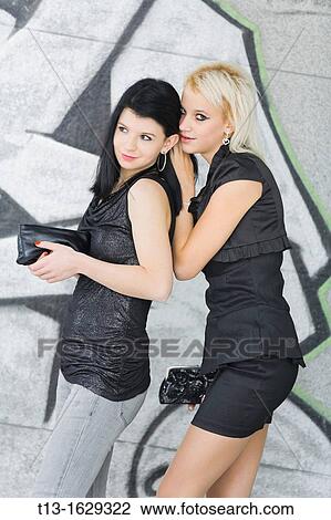 Stock Image - Secretive talk two girls. Fotosearch