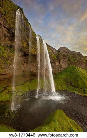 Seljalandsfoss Waterfall, Iceland This waterfall drops 60 metres 200 ft over the cliffs There is a trail behind for easy access to walk behind the falls View Large Photo Image Stock Photograph - Seljalandsfoss Waterfall, Iceland This waterfall drops 60 metres 200 ft over the cliffs There is a trail behind for easy access to walk behind the falls. Fotosearch