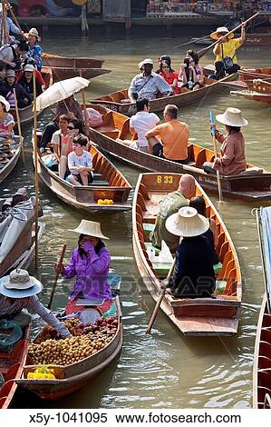 Selling food and souvenirs at the Damnoen Saduak floating market located about 62 miles outside of Bangkok Thailand View Large Photo Image Stock Photography - Selling food and souvenirs at the Damnoen Saduak floating market located about 62 miles outside of Bangkok Thailand. Fotosearch