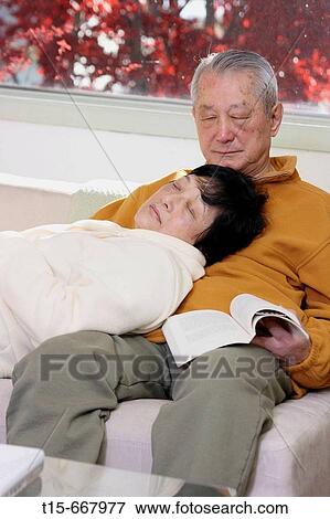 Senior Asian couple falling asleep on sofa while reading View Large Photo Image Stock Photo - Senior Asian couple falling asleep on sofa while reading. Fotosearch