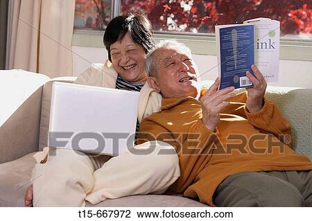Senior Asian couple having fun spending time together by reading and surfing internet on laptop View Large Photo Image Stock Image - Senior Asian couple having fun spending time together by reading and surfing internet on laptop. Fotosearch