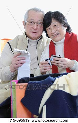 Senior asian couple shopping according to their budget View Large Photo Image Stock Photo - Senior asian couple shopping according to their budget. Fotosearch