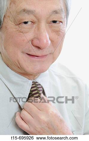 Senior asian man getting ready for work View Large Photo Image Stock Photograph - Senior asian man getting ready for work. Fotosearch