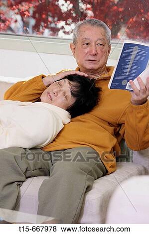 Senior Asian man reading while his wife sleeps in his laps View Large Photo Image Stock Photo - Senior Asian man reading while his wife sleeps in his laps. Fotosearch