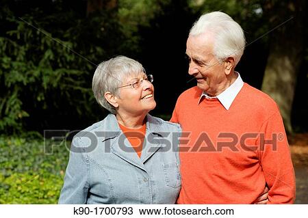Stock Image - Senior caucasian couple, looking happy at each other, standing side by side, Hamburg, Germany, Europe. Fotosearch
