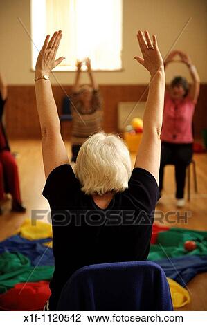 senior citizens participating in a low-impact chair aerobics class in a small village hall in west wales UK View Large Photo Image Stock Image - senior citizens participating in a low-impact chair aerobics class in a small village hall in west wales UK. Fotosearch