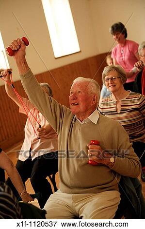 senior citizens participating in a low-impact chair aerobics class in a small village hall in west wales UK View Large Photo Image Stock Photo - senior citizens participating in a low-impact chair aerobics class in a small village hall in west wales UK. Fotosearch