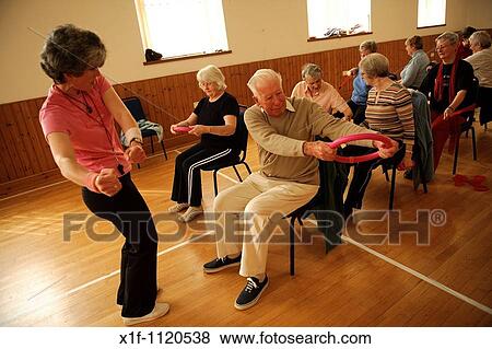 senior citizens participating in a low-impact chair aerobics class in a small village hall in west wales UK View Large Photo Image Stock Photo - senior citizens participating in a low-impact chair aerobics class in a small village hall in west wales UK. Fotosearch