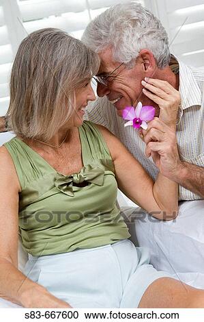 Senior couple being romantic with flower View Large Photo Image Stock Image - Senior couple being romantic with flower. Fotosearch