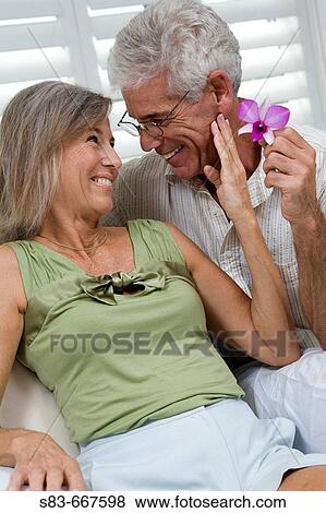 Senior couple being romantic with flower View Large Photo Image Stock Photo - Senior couple being romantic with flower. Fotosearch