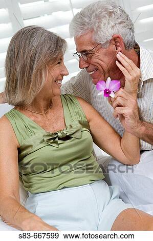 Senior couple being romantic with flower View Large Photo Image Stock Photo - Senior couple being romantic with flower. Fotosearch