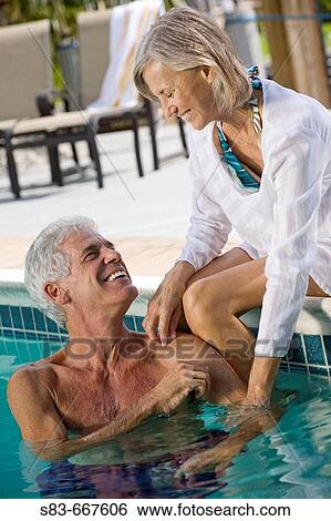Stock Photograph - Senior couple enjoying swimming pool. Fotosearch