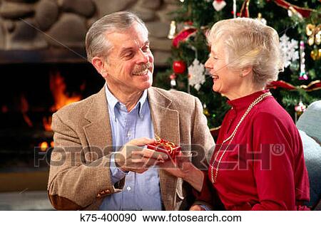 Senior couple exchanging Christmas presents View Large Photo Image Stock Image - Senior couple exchanging Christmas presents. Fotosearch