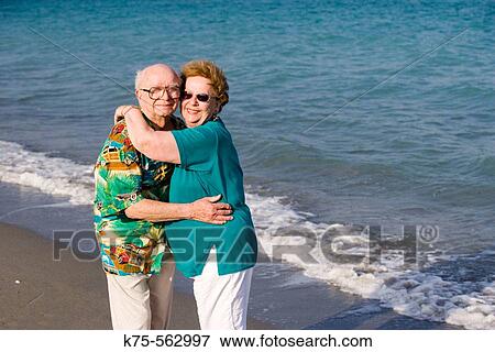 Stock Photo - Senior couple hugging at the beach. Fotosearch
