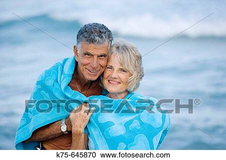 Senior couple hugging together wrapped in beach towel View Large Photo Image Stock Image - Senior couple hugging together wrapped in beach towel. Fotosearch