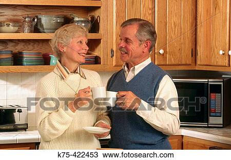 Stock Image - senior couple in kitchen. Fotosearch