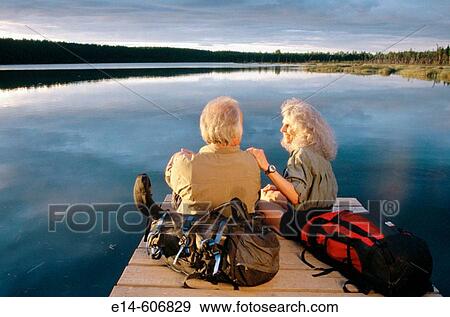 Senior couple of hikers on dock at sunset. Otter Lake. Alaska. USA View Large Photo Image Stock Photo - Senior couple of hikers on dock at sunset. Otter Lake. Alaska. USA. Fotosearch