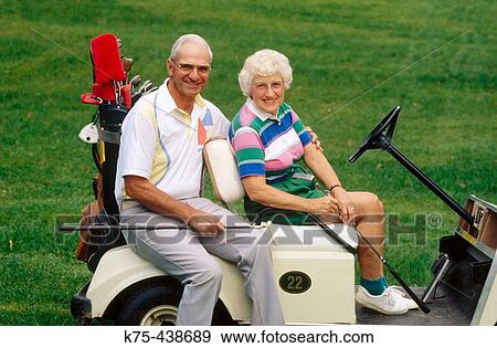 Stock Photo - Senior couple on golf cart. Fotosearch