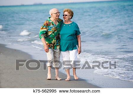 Stock Photography - Senior couple strolling along the beach. Fotosearch