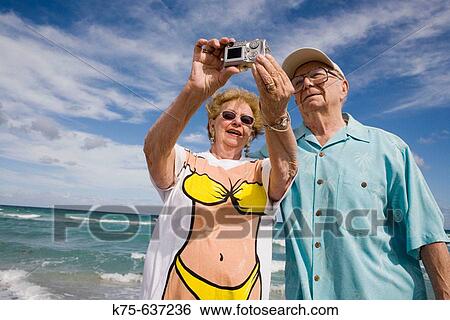 Senior couple taking a picture of themselves with digital camera. View Large Photo Image Stock Photograph - Senior couple taking a picture of themselves with digital camera.. Fotosearch