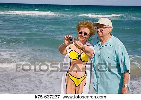 Senior couple taking picture of themselves at beach. View Large Photo Image Stock Photo - Senior couple taking picture of themselves at beach.. Fotosearch