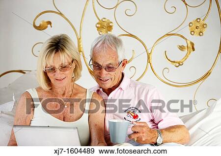 Senior couple using laptop computer View Large Photo Image Stock Photo - Senior couple using laptop computer. Fotosearch