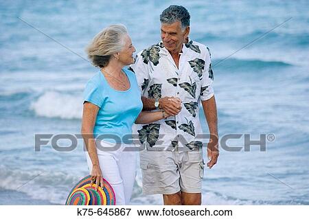 Senior couple walking hand in hand at beach View Large Photo Image Stock Photo - Senior couple walking hand in hand at beach. Fotosearch