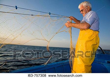Senior fisherman fishing with nets in his boat, Cambrils. Tarragona province, Catalonia, Spain View Large Photo Image Stock Photo - Senior fisherman fishing with nets in his boat, Cambrils. Tarragona province, Catalonia, Spain. Fotosearch