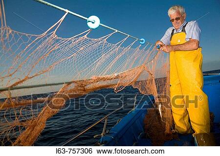 Senior fisherman fishing with nets in his boat, Cambrils. Tarragona province, Catalonia, Spain View Large Photo Image Stock Photograph - Senior fisherman fishing with nets in his boat, Cambrils. Tarragona province, Catalonia, Spain. Fotosearch