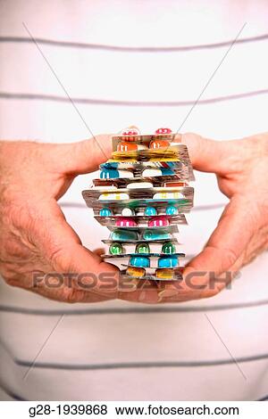 Senior hands close up holding a colored pile of pills and tablets symbol of over medication View Large Photo Image Stock Photo - Senior hands close up holding a colored pile of pills and tablets symbol of over medication. Fotosearch