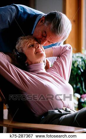 Senior listening to music and getting a kiss View Large Photo Image Stock Photo - Senior listening to music and getting a kiss. Fotosearch