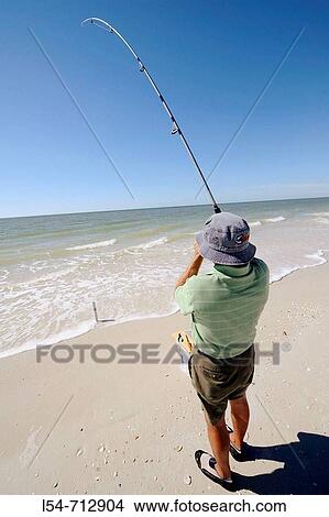 Senior man fishing for recreation in the Gulf of Mexico at Naples Florida View Large Photo Image Picture - Senior man fishing for recreation in the Gulf of Mexico at Naples Florida. Fotosearch