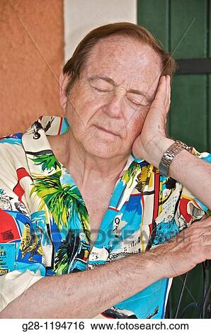 Stock Photograph - Senior man having a nap sitting. Fotosearch