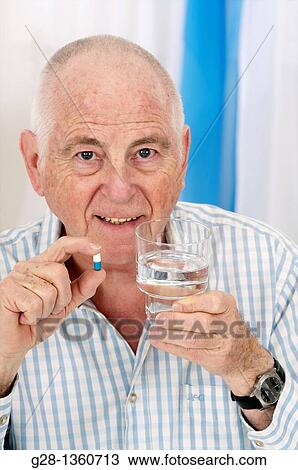 Senior man holding a pill in one hand and a glass of water in hte other about to take his medical treatment View Large Photo Image Stock Image - Senior man holding a pill in one hand and a glass of water in hte other about to take his medical treatment. Fotosearch