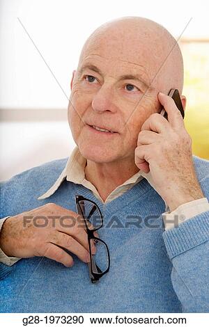 Senior man in a blue sweater pullover, holding a pair of glasses and smiling View Large Photo Image Stock Image - Senior man in a blue sweater pullover, holding a pair of glasses and smiling. Fotosearch