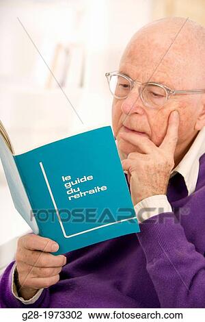 Senior man in a purple pullover and wearing glasses reading an advice retirement booklet View Large Photo Image Stock Image - Senior man in a purple pullover and wearing glasses reading an advice retirement booklet. Fotosearch