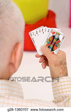 Senior man playing cards seen from behind at home View Large Photo Image Stock Photo - Senior man playing cards seen from behind at home. Fotosearch