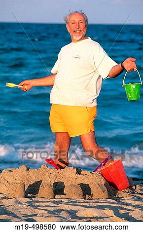 senior man playing in the sand View Large Photo Image Stock Image - senior man playing in the sand. Fotosearch