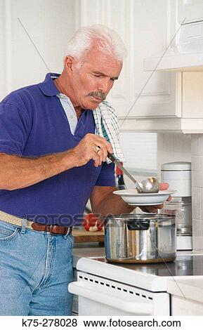 Stock Photo - Senior man pouring himself some soup (or stew). Fotosearch