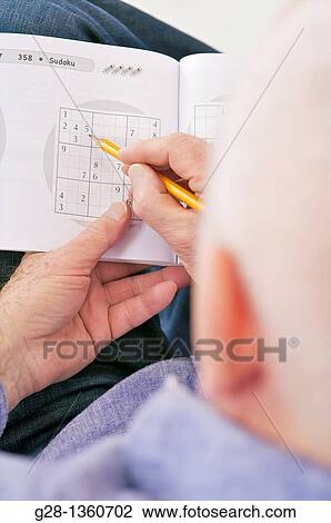 Senior man reading a book and exercising his memory with Sudoku tests to prevent Alzheimer disease View Large Photo Image Stock Image - Senior man reading a book and exercising his memory with Sudoku tests to prevent Alzheimer disease. Fotosearch