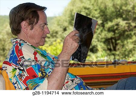 Senior man resting and reading a magazine on a green country background View Large Photo Image Picture - Senior man resting and reading a magazine on a green country background. Fotosearch