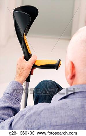 Senior man seen from behind waiting with his hand on a crutch in a clinic waiting room or medical center View Large Photo Image Stock Image - Senior man seen from behind waiting with his hand on a crutch in a clinic waiting room or medical center. Fotosearch
