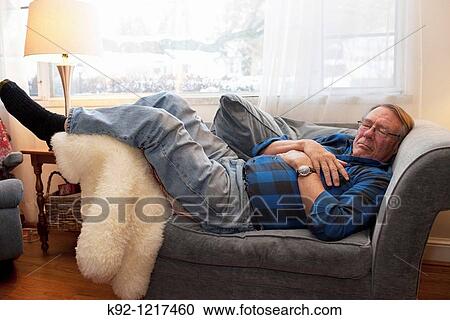 Stock Image - Senior man sleeping on a chair.. Fotosearch