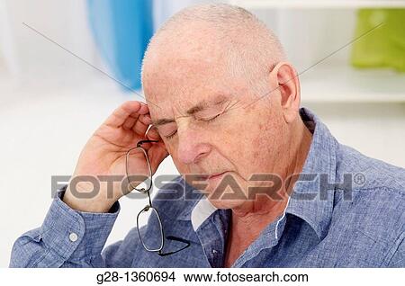 Senior man taking a nap, with his glasses in one hand at home View Large Photo Image Picture - Senior man taking a nap, with his glasses in one hand at home. Fotosearch