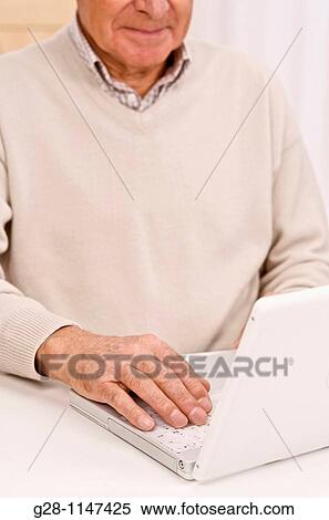 Senior man using his computer View Large Photo Image Stock Photography - Senior man using his computer. Fotosearch