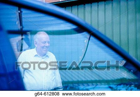 Stock Photo - Senior man viewed through car window. Fotosearch
