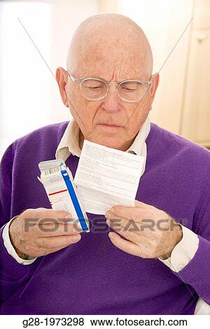 Senior man wearing glasses, looking puzzled and worried reading a prescription which he is holding in his hand View Large Photo Image Stock Photo - Senior man wearing glasses, looking puzzled and worried reading a prescription which he is holding in his hand. Fotosearch