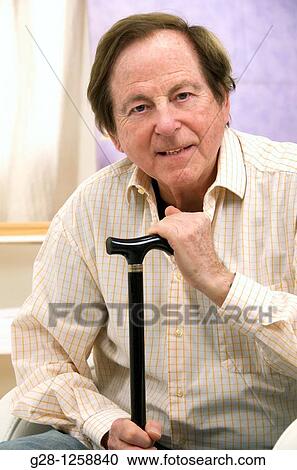 senior man with his hands resting on his walking stick View Large Photo Image Stock Image - senior man with his hands resting on his walking stick. Fotosearch
